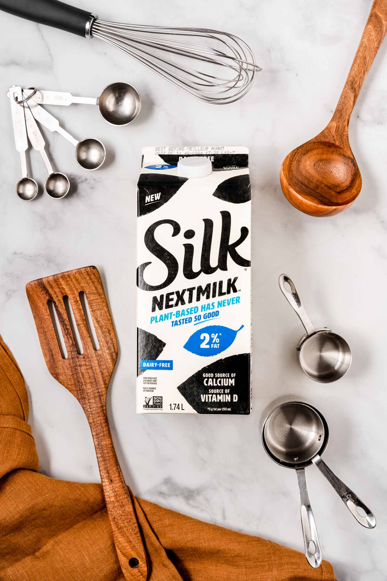 Silk Nextmilk on marble backdrop with cooking utensils all around