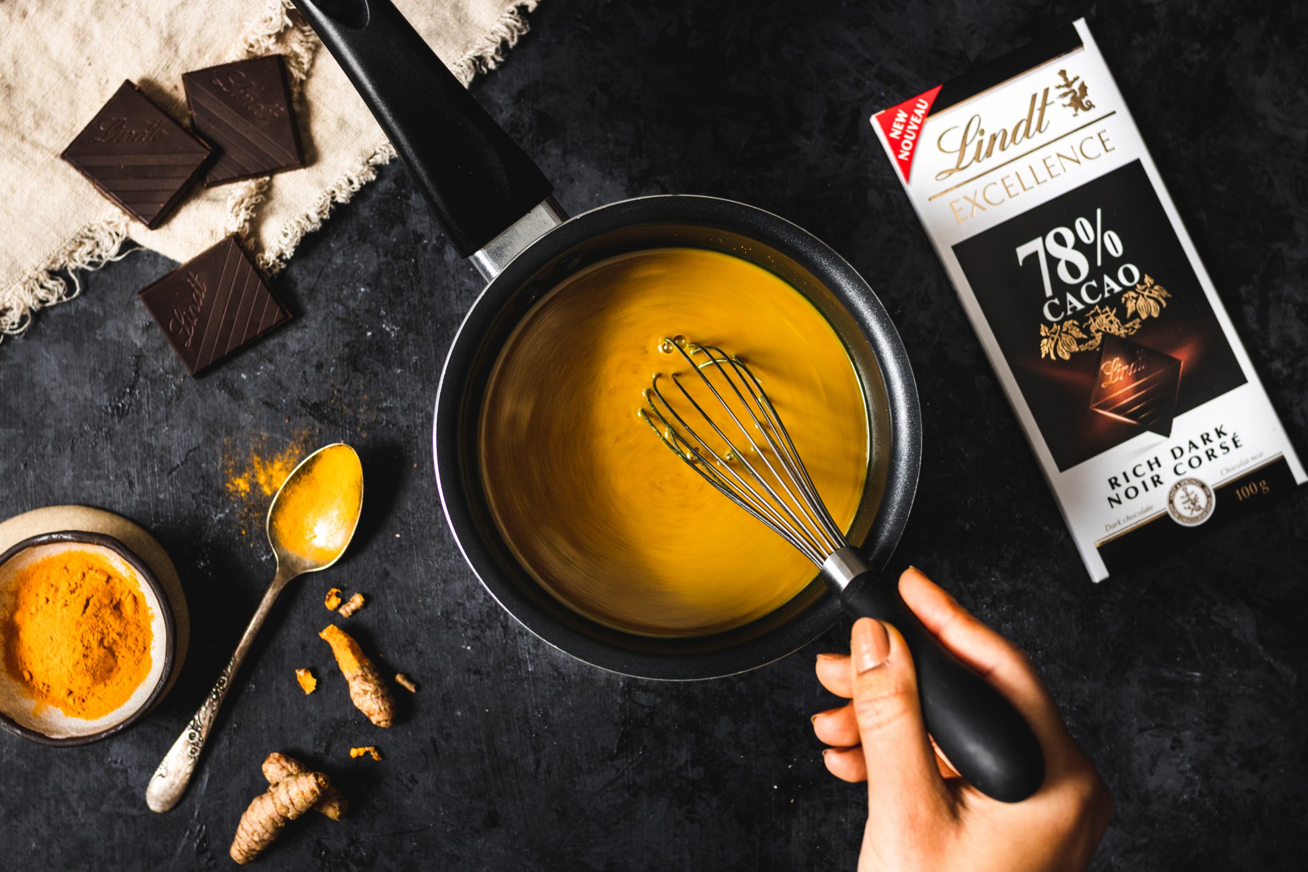 golden milk being stirred in a pot