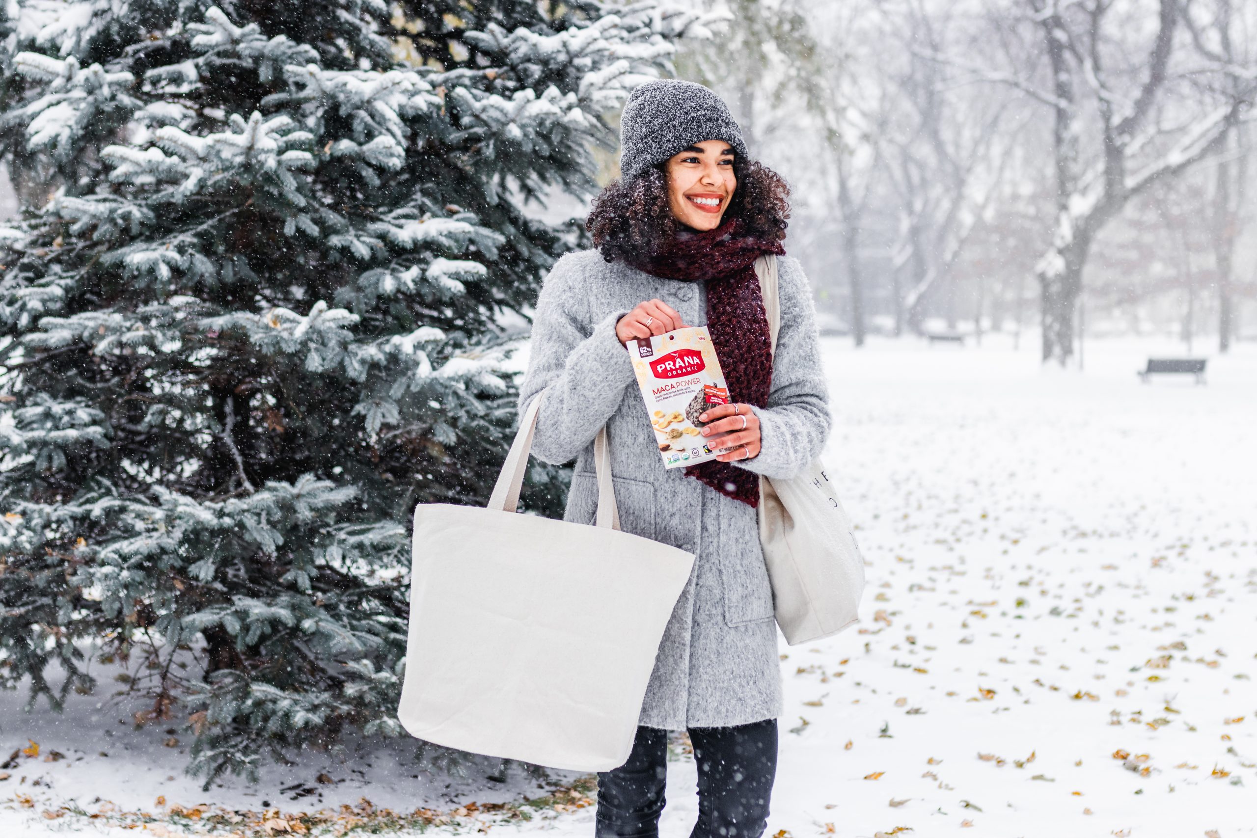 Woman eating Prana chocolate outside in the snow