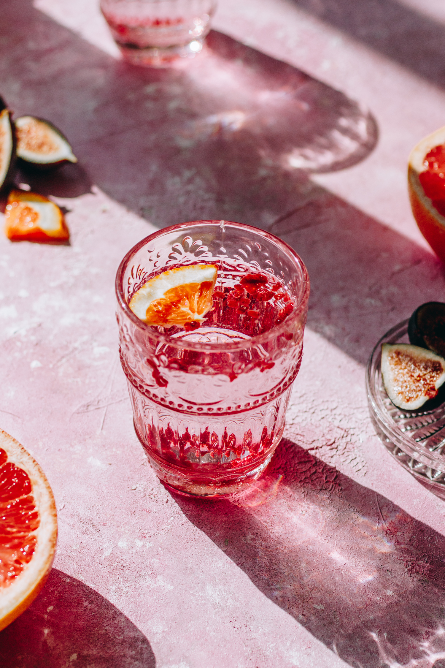 Glass of pink cocktail with a blood orange floating