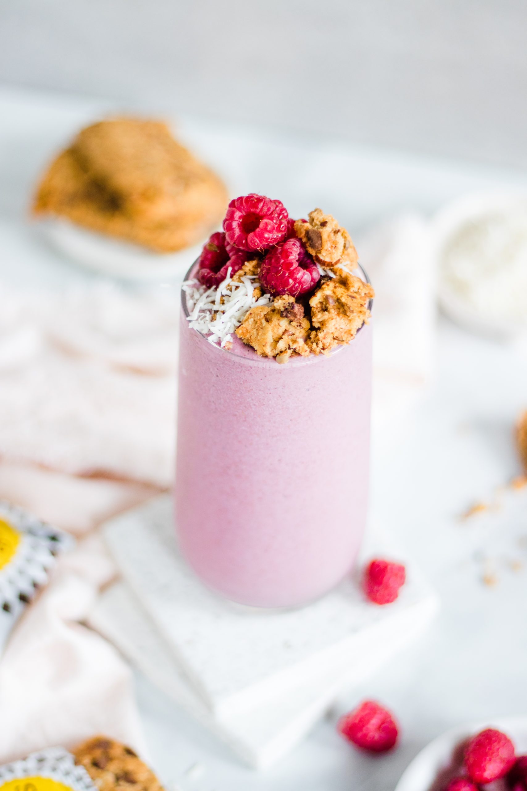 Berry smoothie in a glass topped with crumbled oatmeal cookies