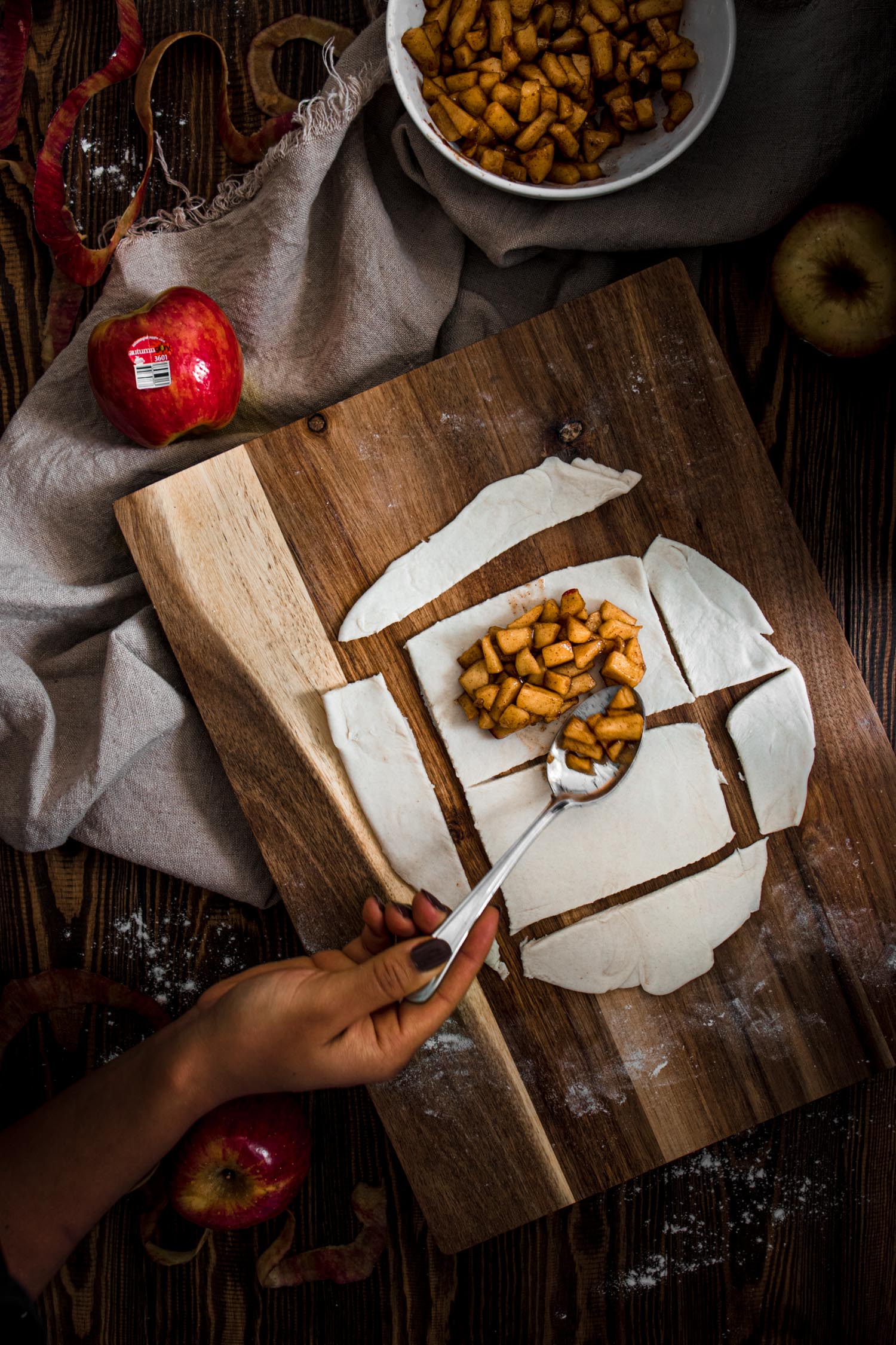 Pop tarts being filled with cooked apples.