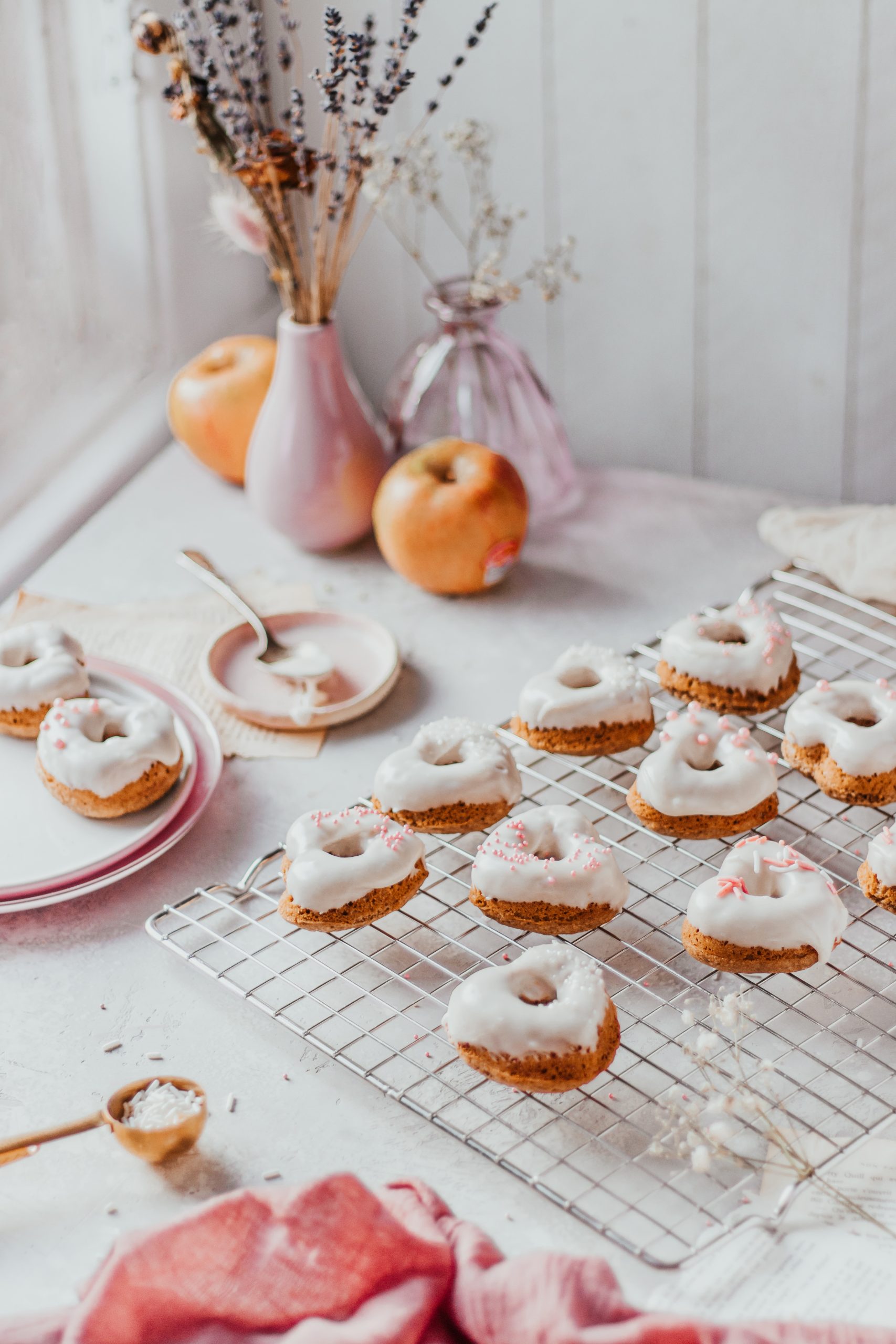 Heart shaped apple donuts cooling off on a cooling rack.