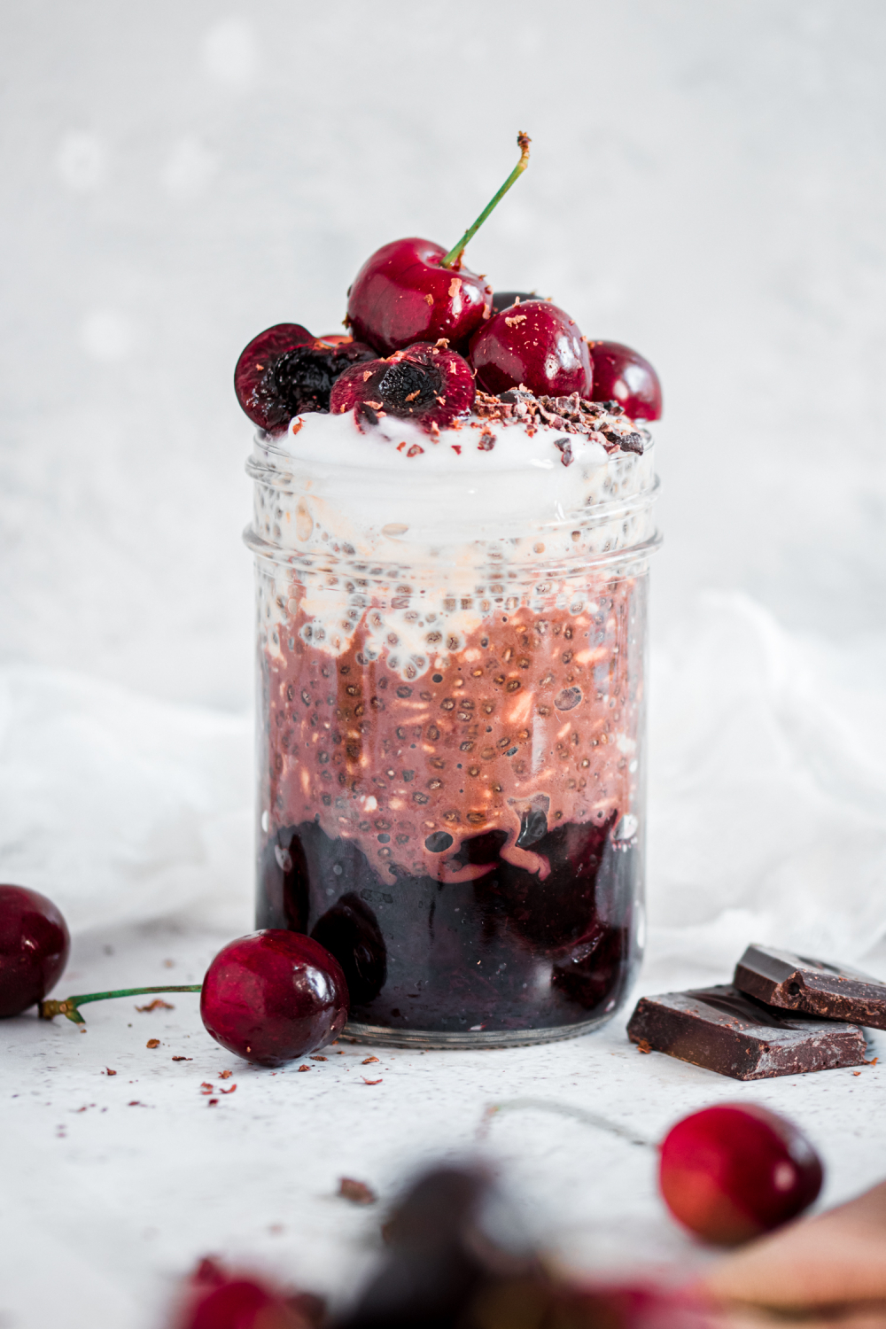 Layered Overnight oats surrounded by cherries and dark chocolate