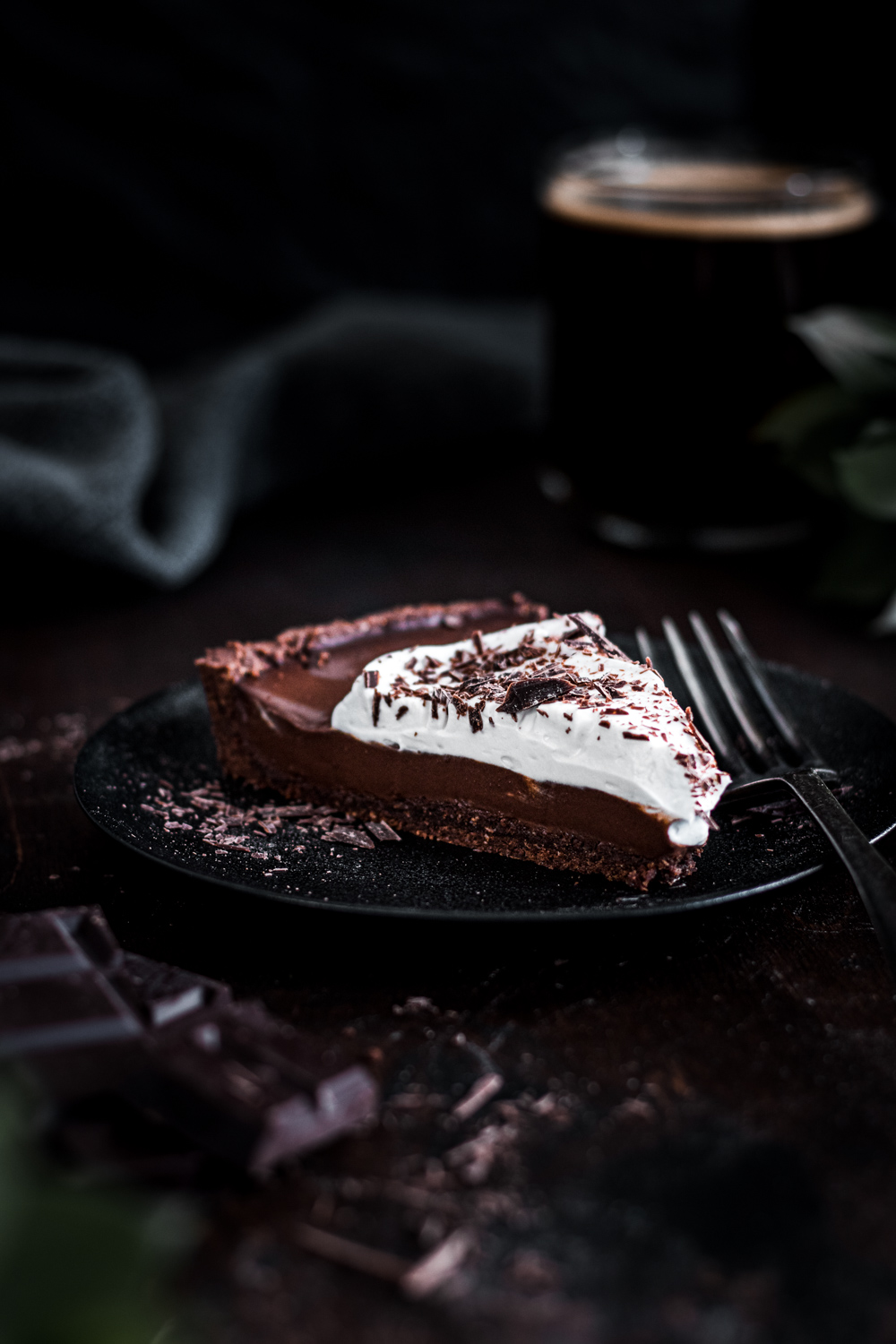 Closeup of a chocolate espresso tart topped with coconut whipped cream.