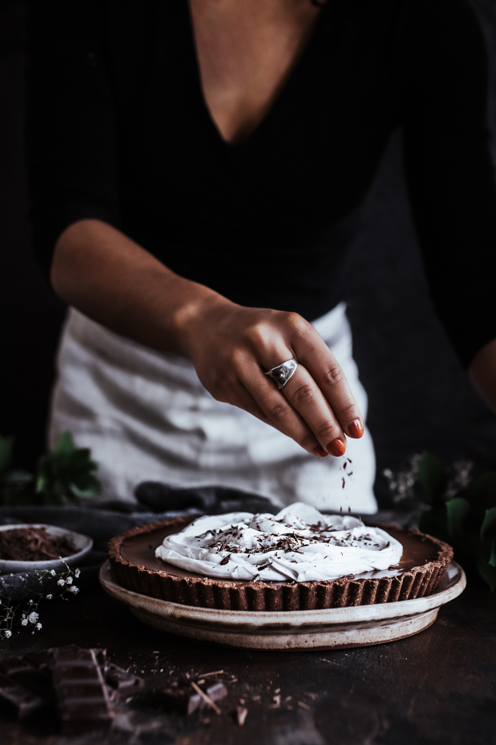 Chocolate Shavings being sprinkled onto chocolate tart.
