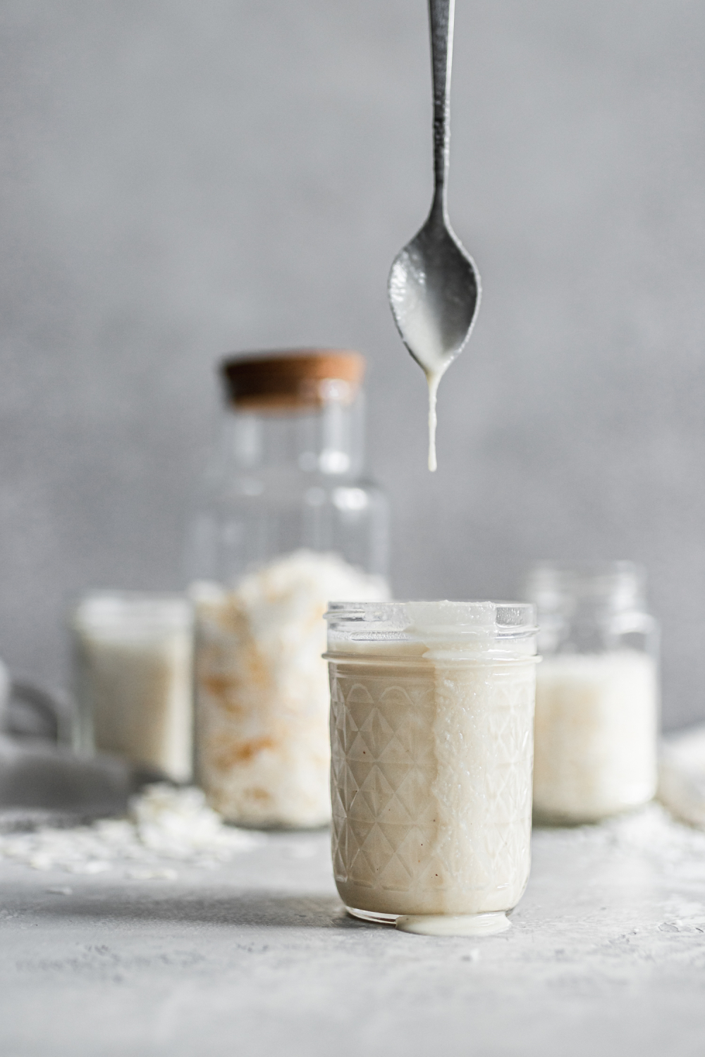 Spoon coming out of a jar. Coated in coconut butter.