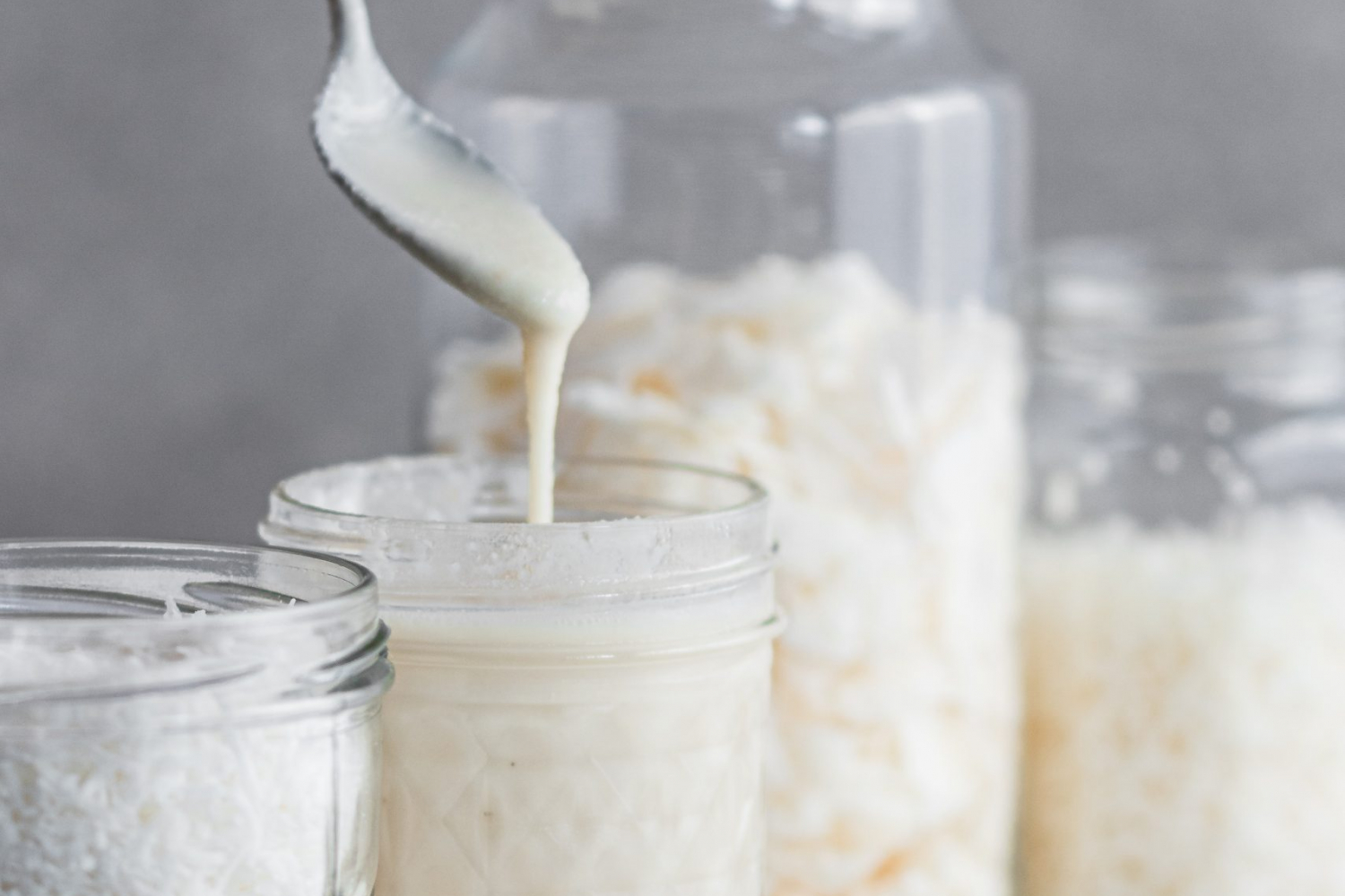 Coconut butter being scooped from a mason jar.