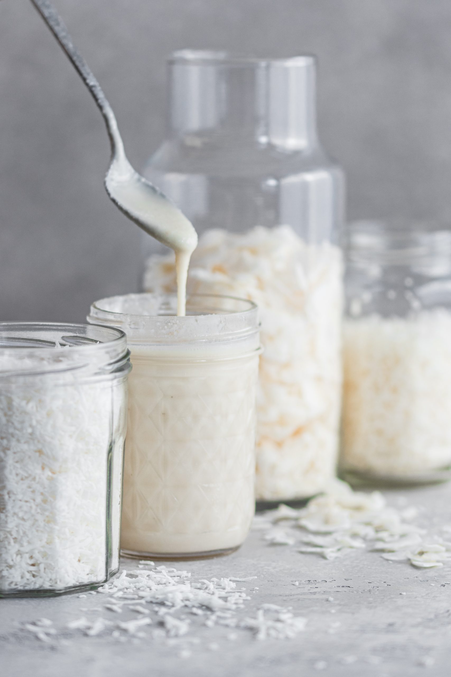 Coconut butter being scooped from a mason jar.