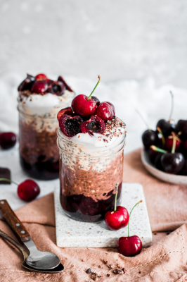 Two portions of Layered Black Forest Overnight Oats in mason jars