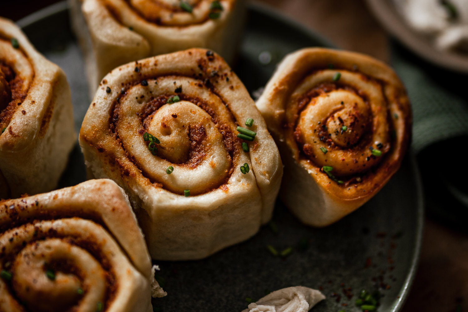 Sundried tomato rolls on a plate with a knife with cream cheese