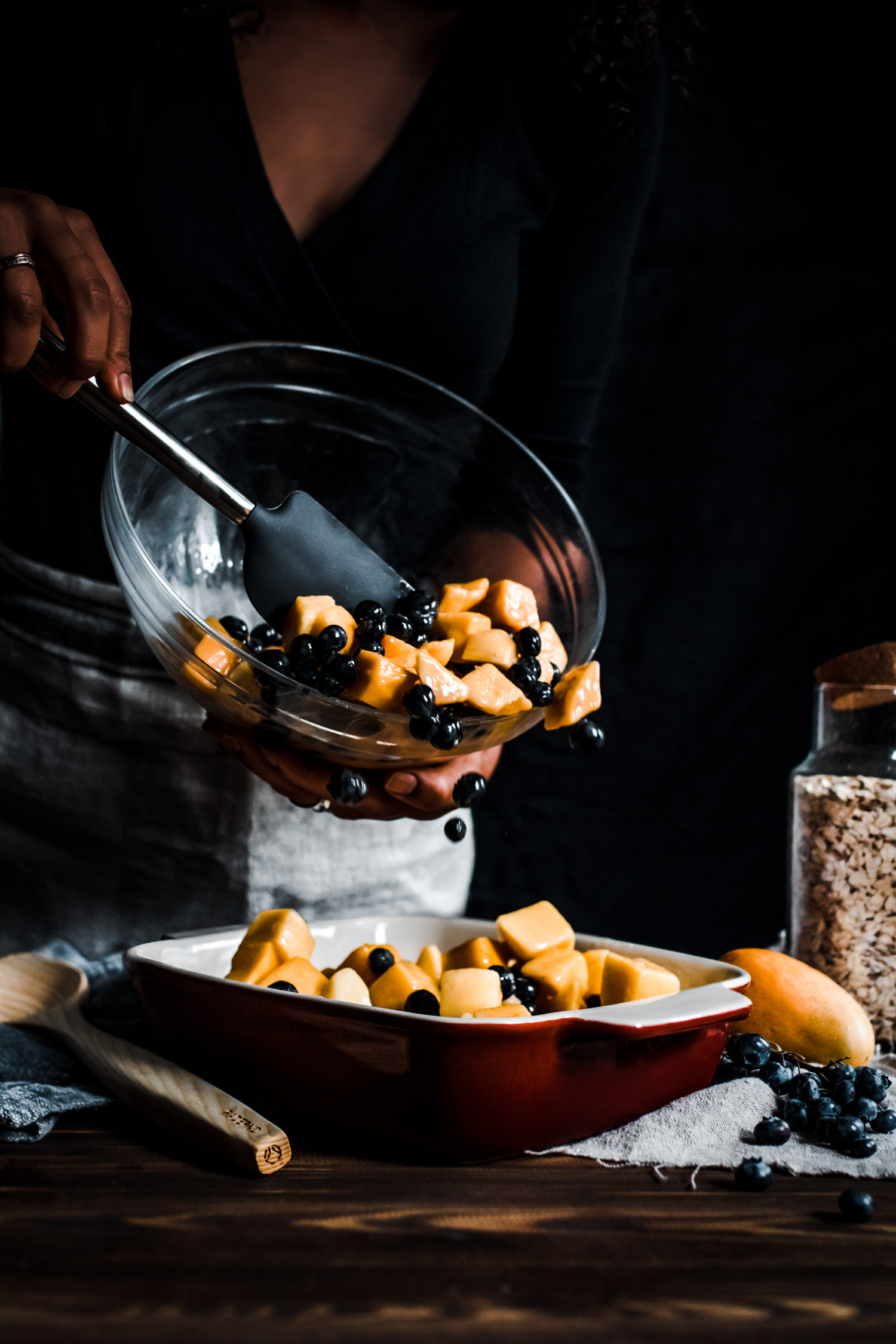 Frozen fruits being poured into a baking dish