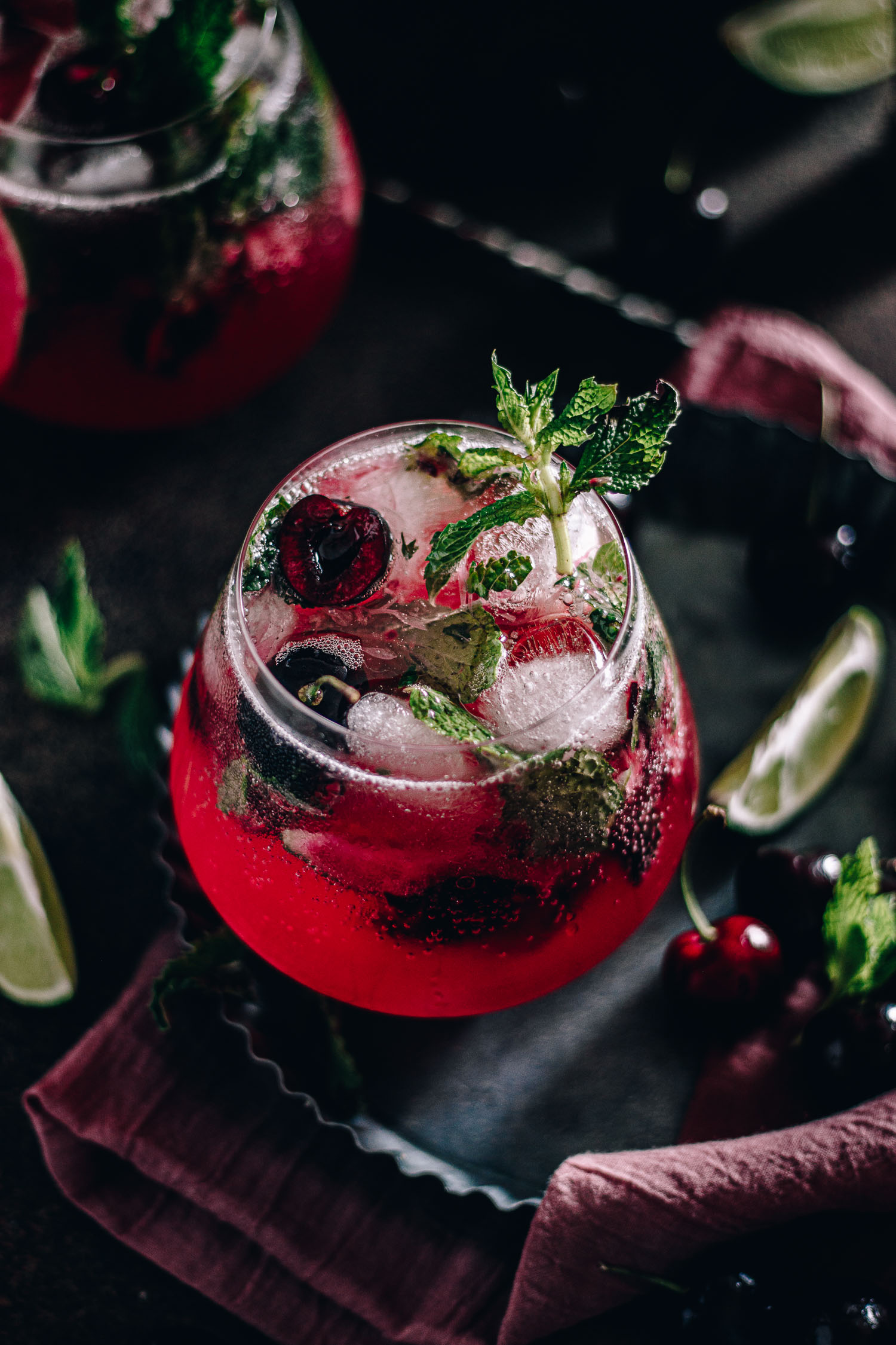 Cherry mojito in a glass with fresh mint coming out