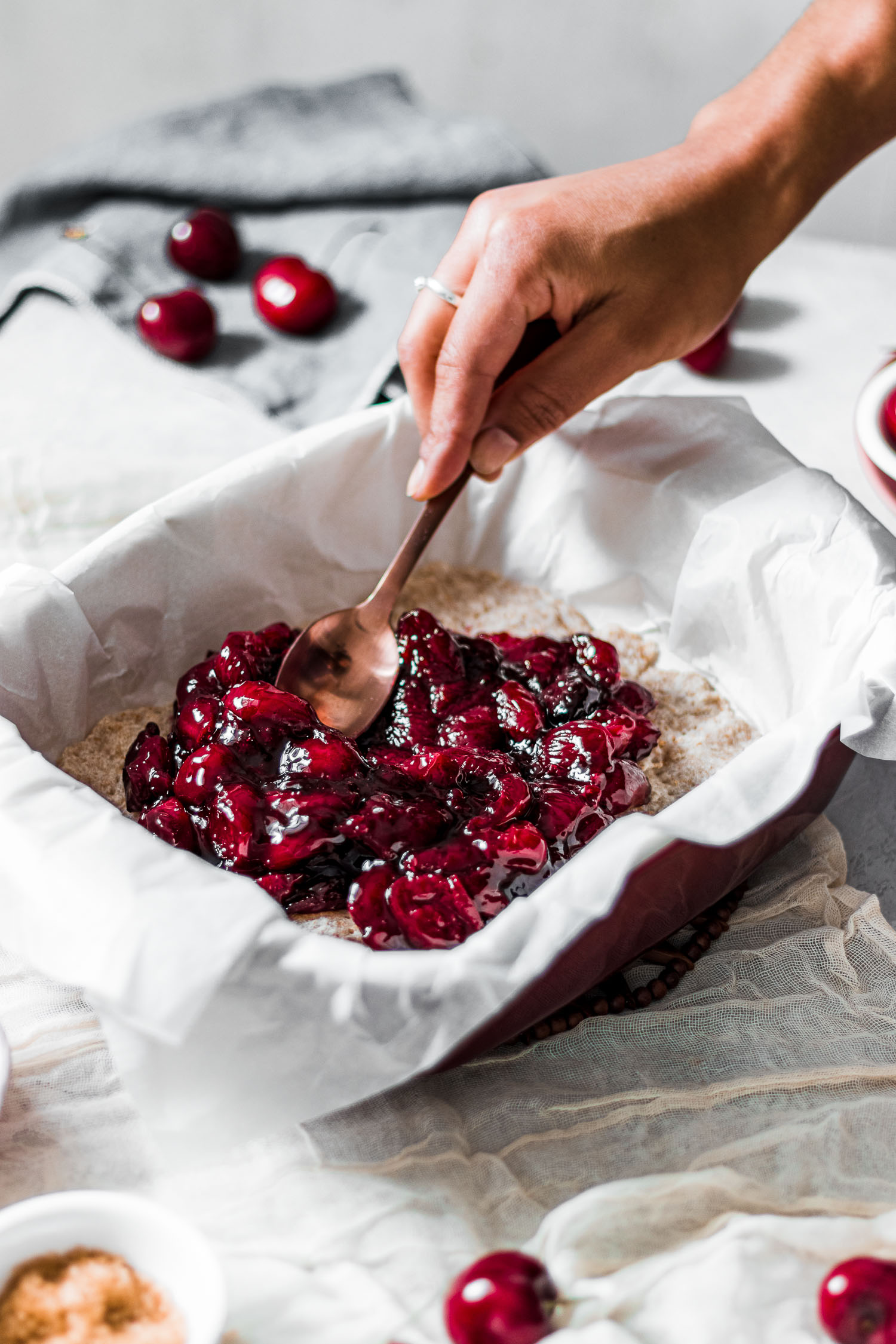 Cherry filling being spread on crust before baking