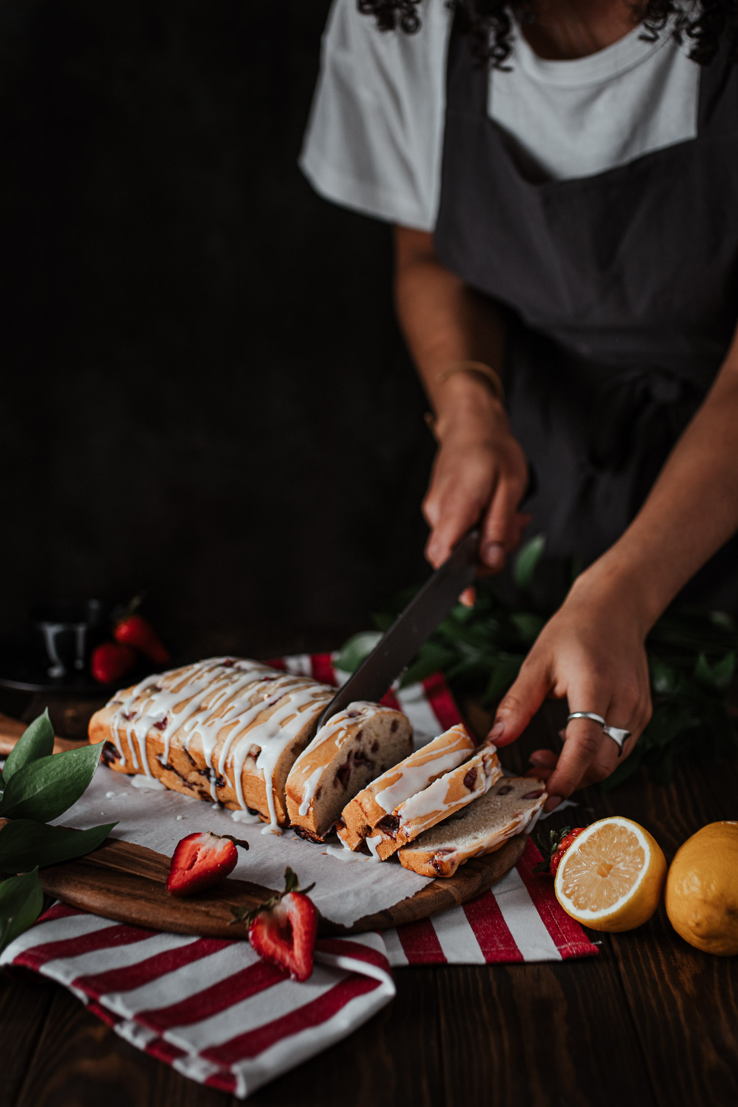 Strawberry lemon loaf being cut into slices.