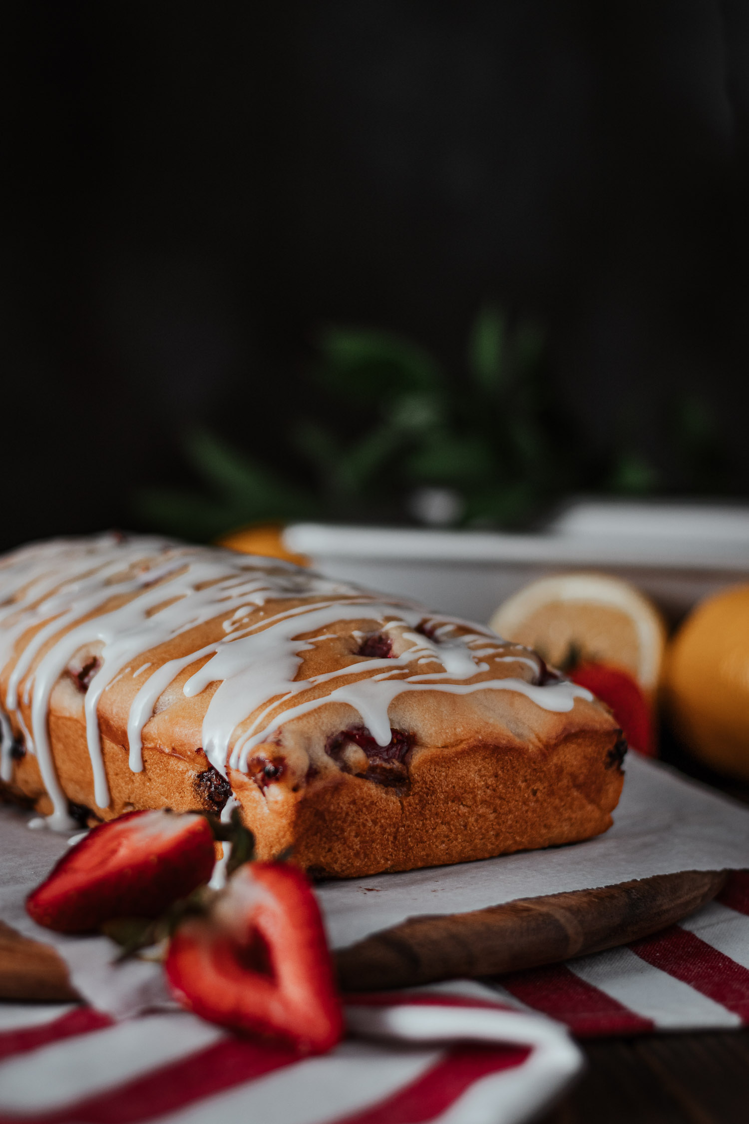 Closeup of glaze falling on strawberry lemon loaf