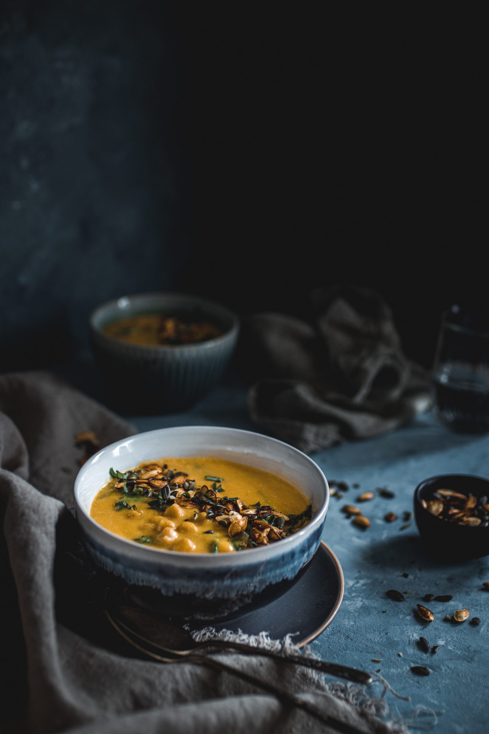 Thai Pumpkin Soup in a blue and white bowl garnished with pumpkin seeds