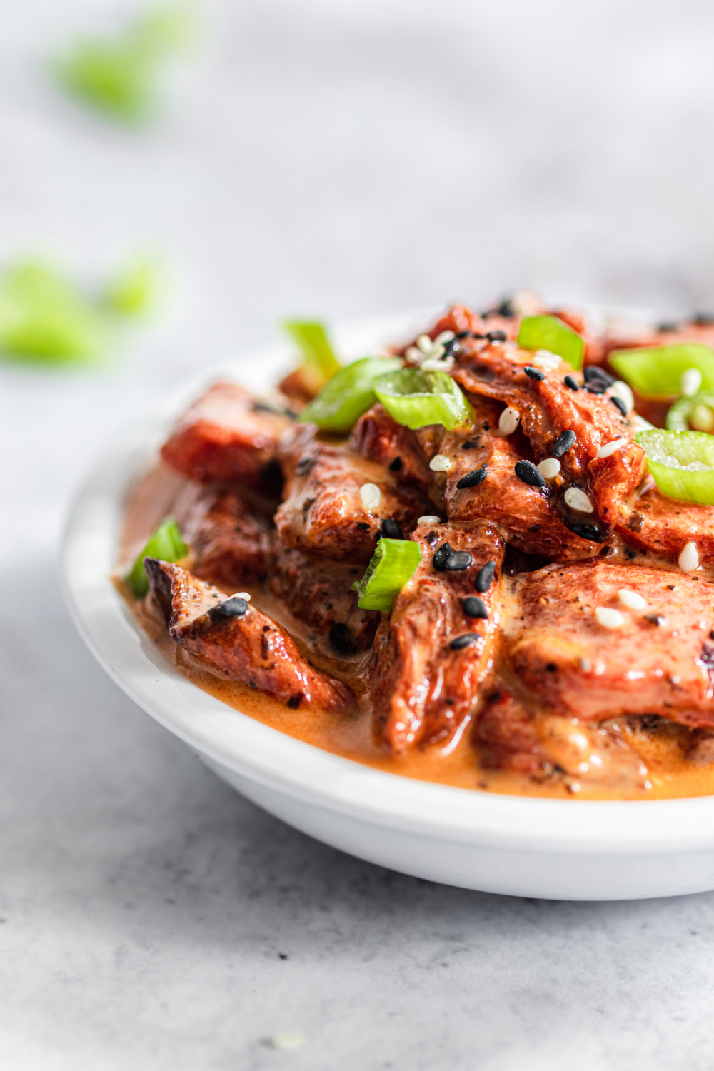 Vegan watermelon tuna in a small bowl. Garnished with sesame seeds and green onions