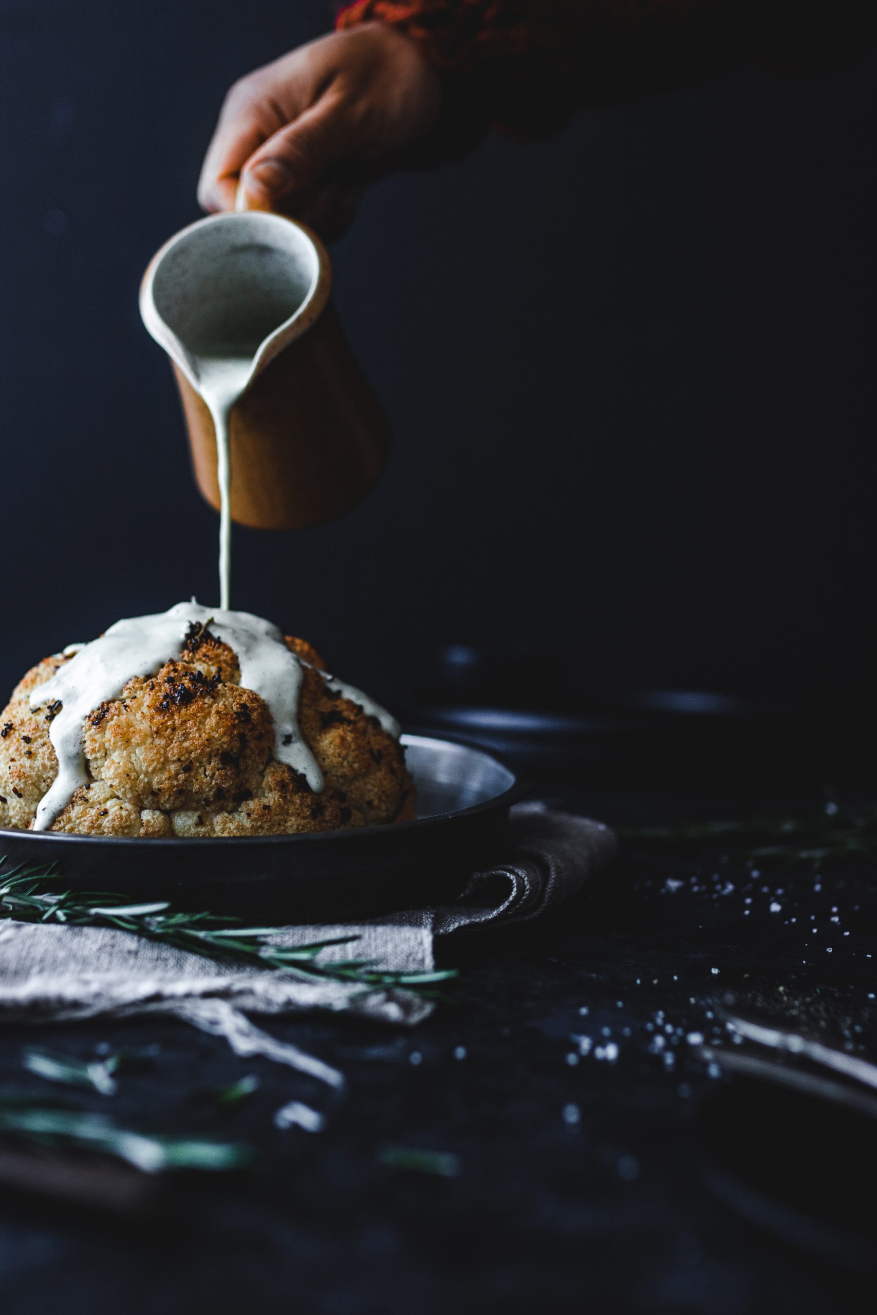 Whole roasted cauliflower with sauce poured on it