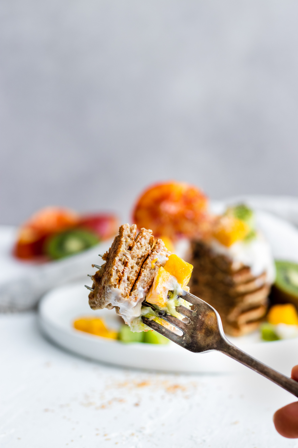 Tropical Coconut Pancakes topped with blood orange, kiwi, mango and coconut yogurt