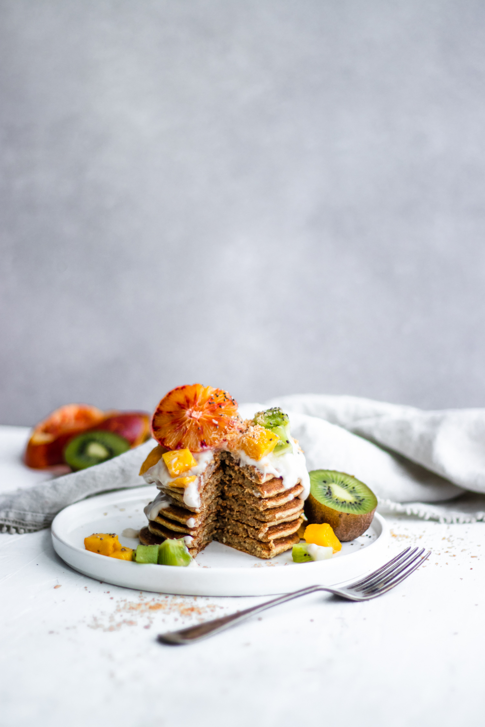 Tropical Coconut Pancakes topped with blood orange, kiwi, mango and coconut yogurt