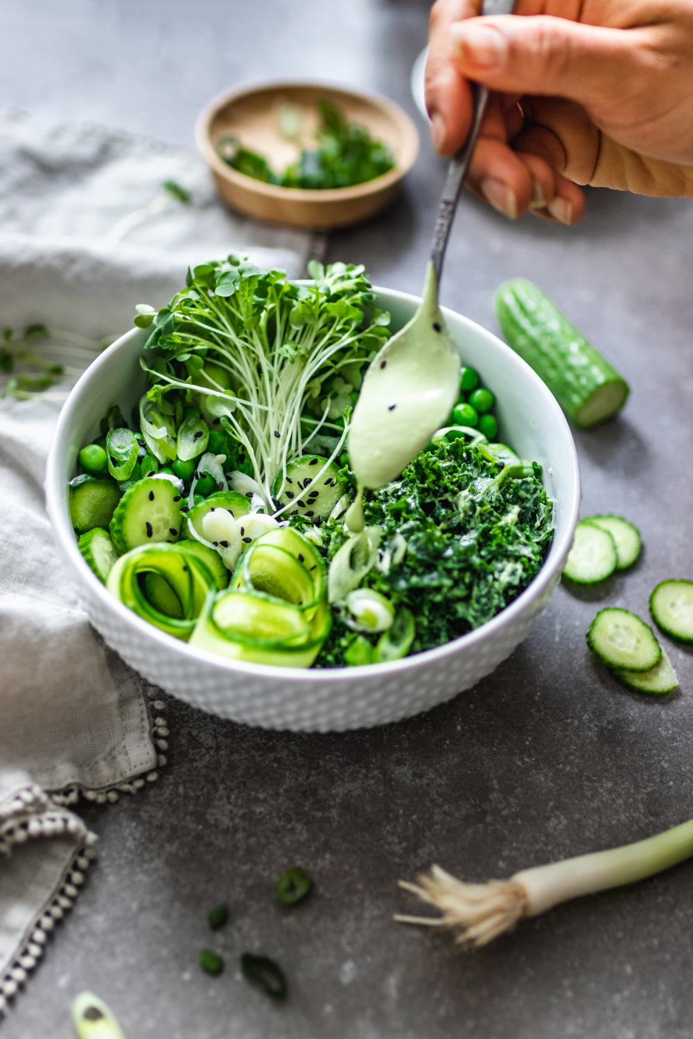 Green Goddess Salad with Cashew Basil Dressing with dressing being poured