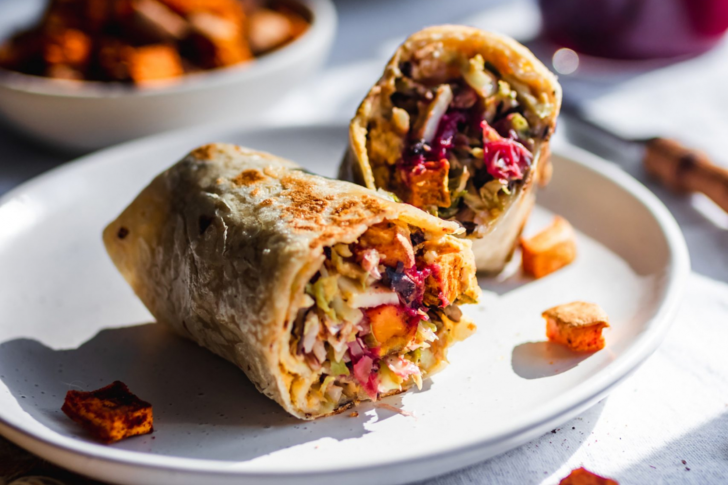 Vegan wrap cut in half, stuffed with squash, brussels sprouts, cranberries, sweet potatoes page-recipe-item apples