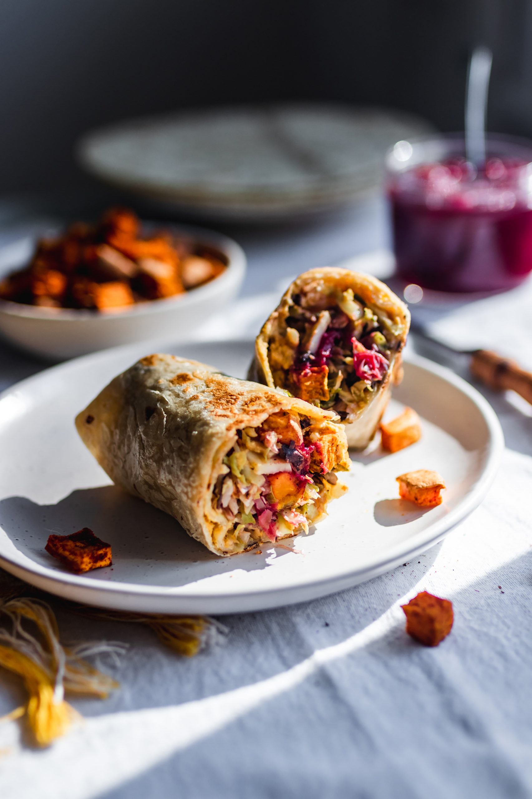 Vegan wrap cut in half, stuffed with squash, brussels sprouts, cranberries, sweet potatoes item-snippet-recipe apples