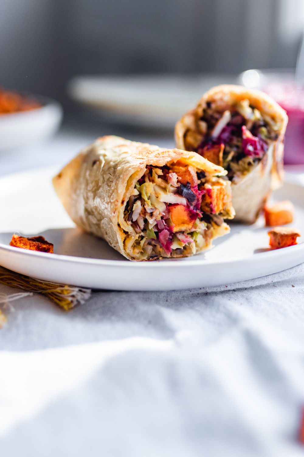 Vegan wrap cut in half, stuffed with squash, brussels sprouts, cranberries, sweet potatoes block-cover-recipe apples
