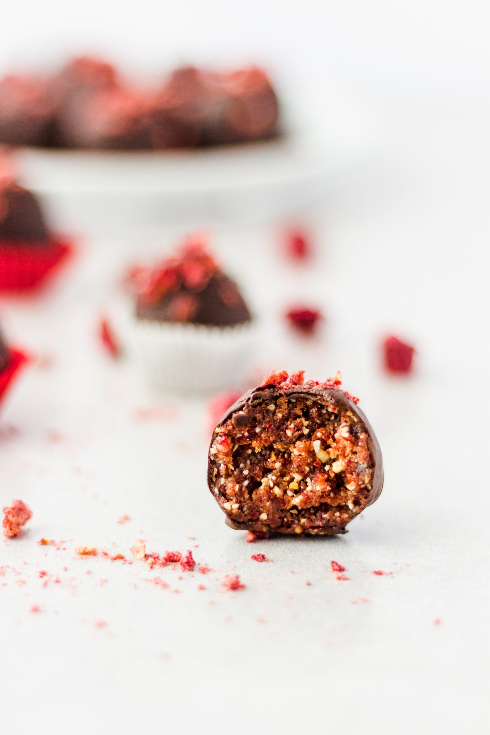 Chocolate Covered Cherry Cashew Truffles with a bite taken out of one