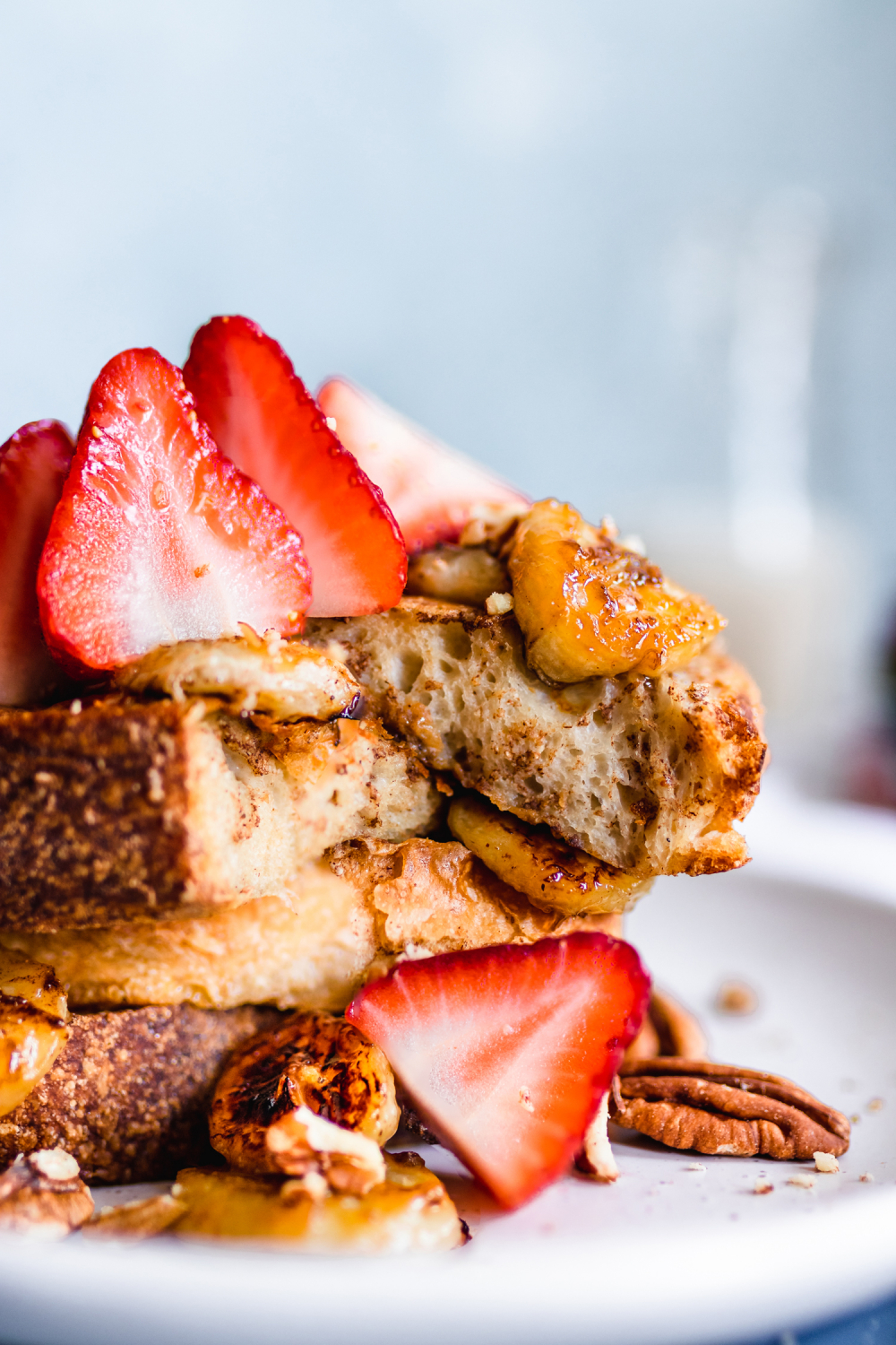 stack of vegan French toast served with caramelized bananas, strawberries, and pecans