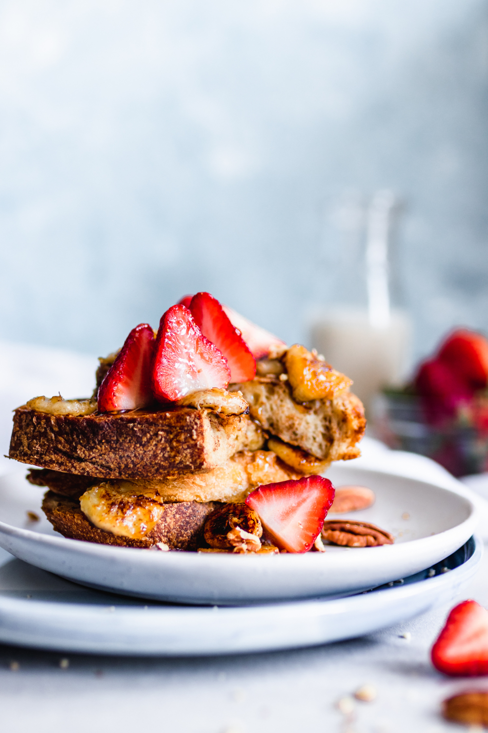 stack of vegan French toast served with caramelized bananas, strawberries, and pecans