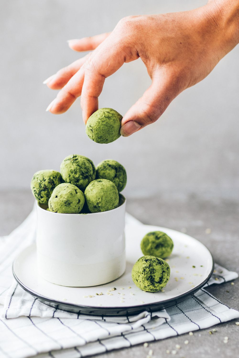 Hand picking up a Spirulina Hemp and Coconut Bliss Ball