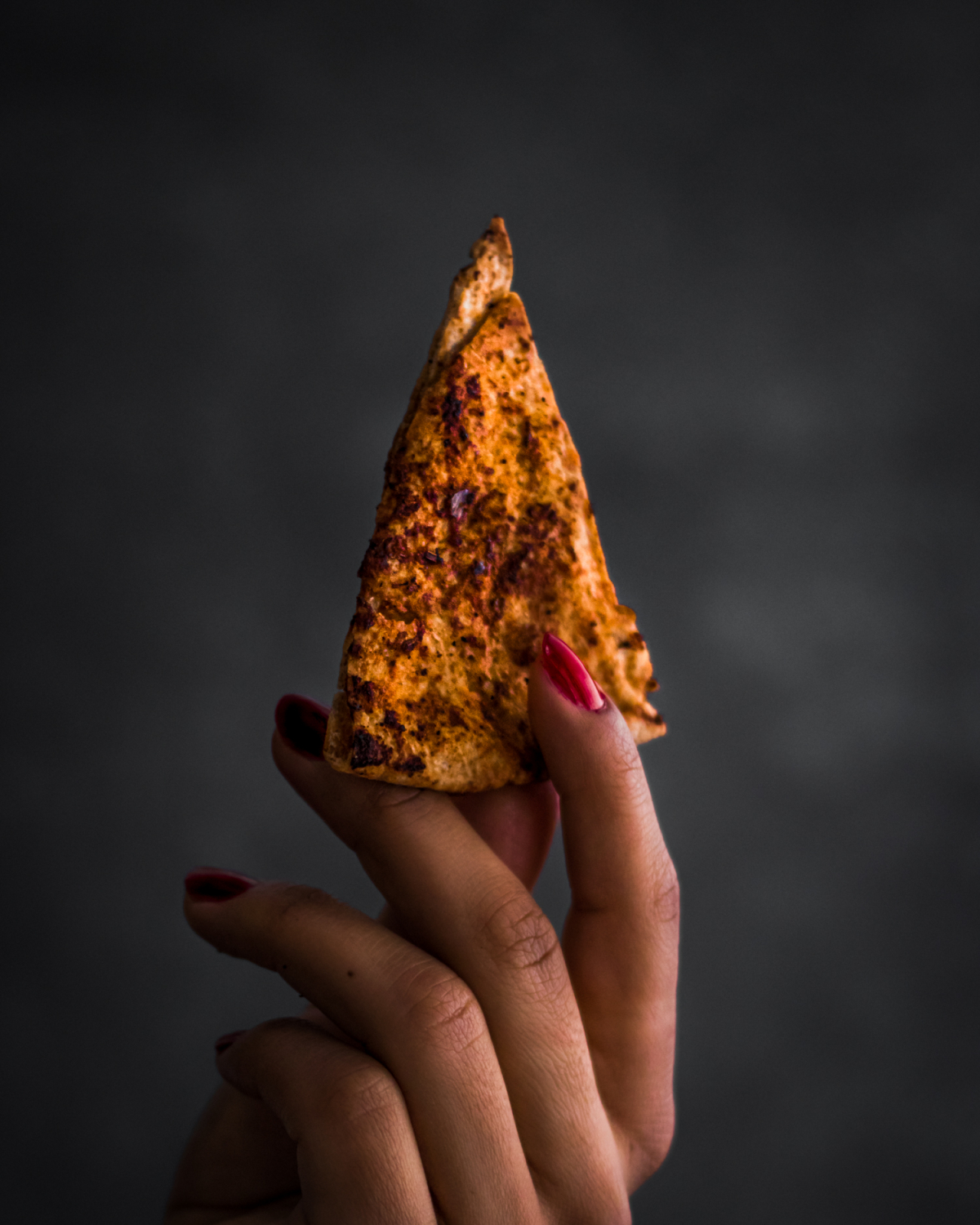 Hand holding Stack of Whole Wheat Chili and Lime Pita Chips