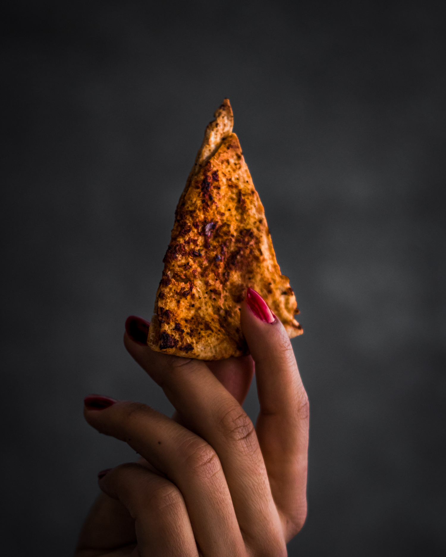 Hand holding Stack of Whole Wheat Chili and Lime Pita Chips