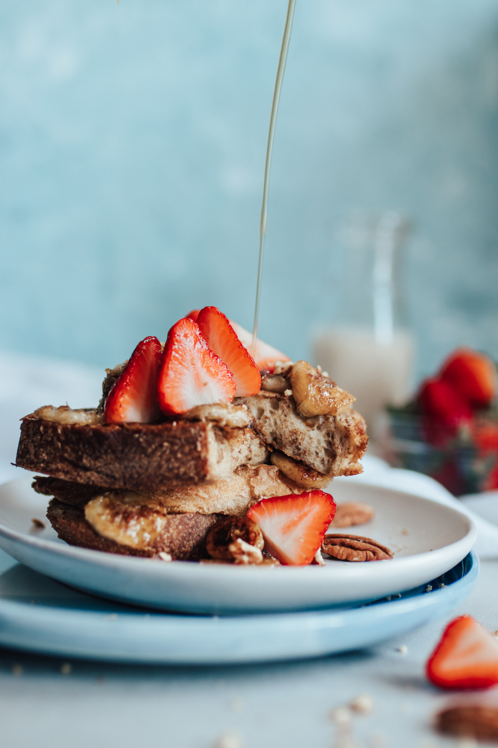 French Toast Stack with strawberries and maple syrup pouring