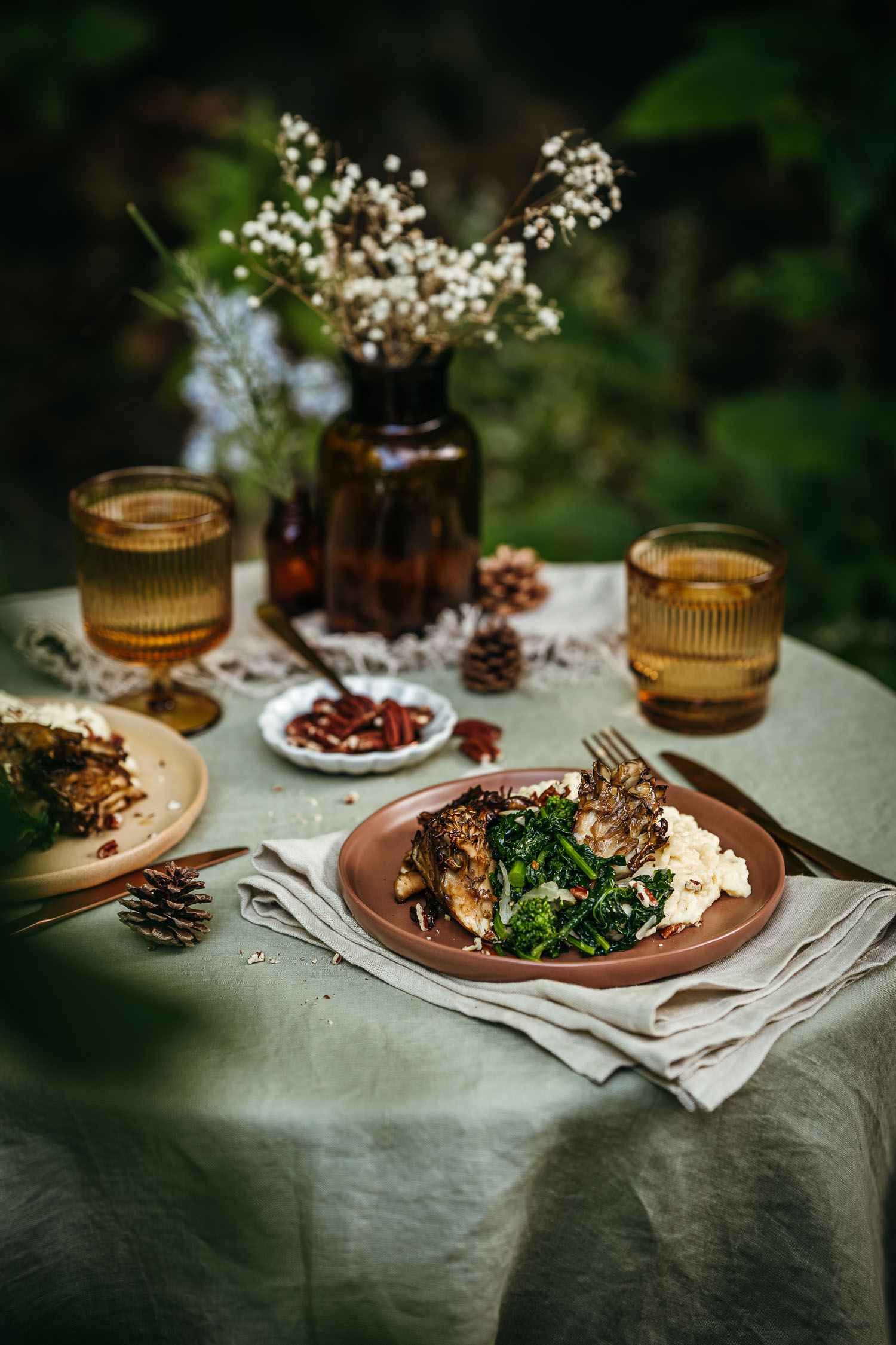 Plate set on a table outside. Served in it are Maple Roasted Maitake Mushrooms with Butter Miso Mashed Potatoes