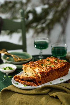 Spring Onion Pull Apart Bread set on a table, surrounded by kombucha and nature.