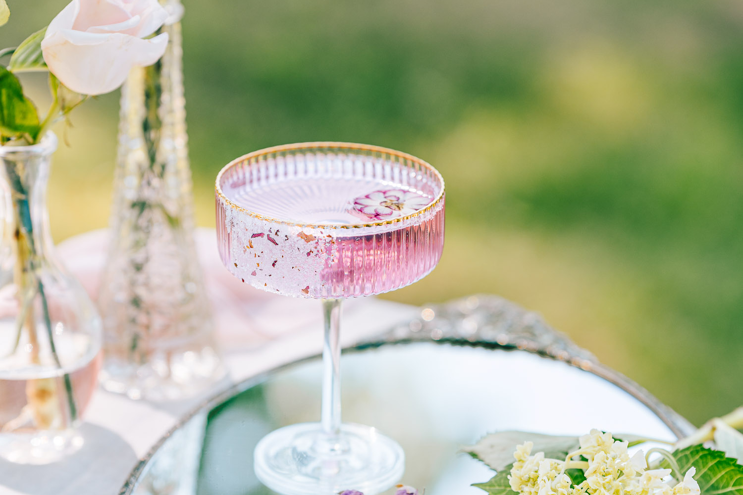 Rose Gin Tonic in a garden surrounded by flowers