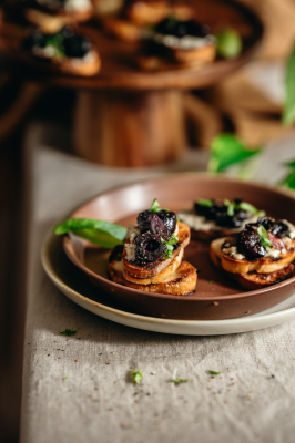Grilled baguette topped with vegan cheese, roasted cherries, basil, and pepper