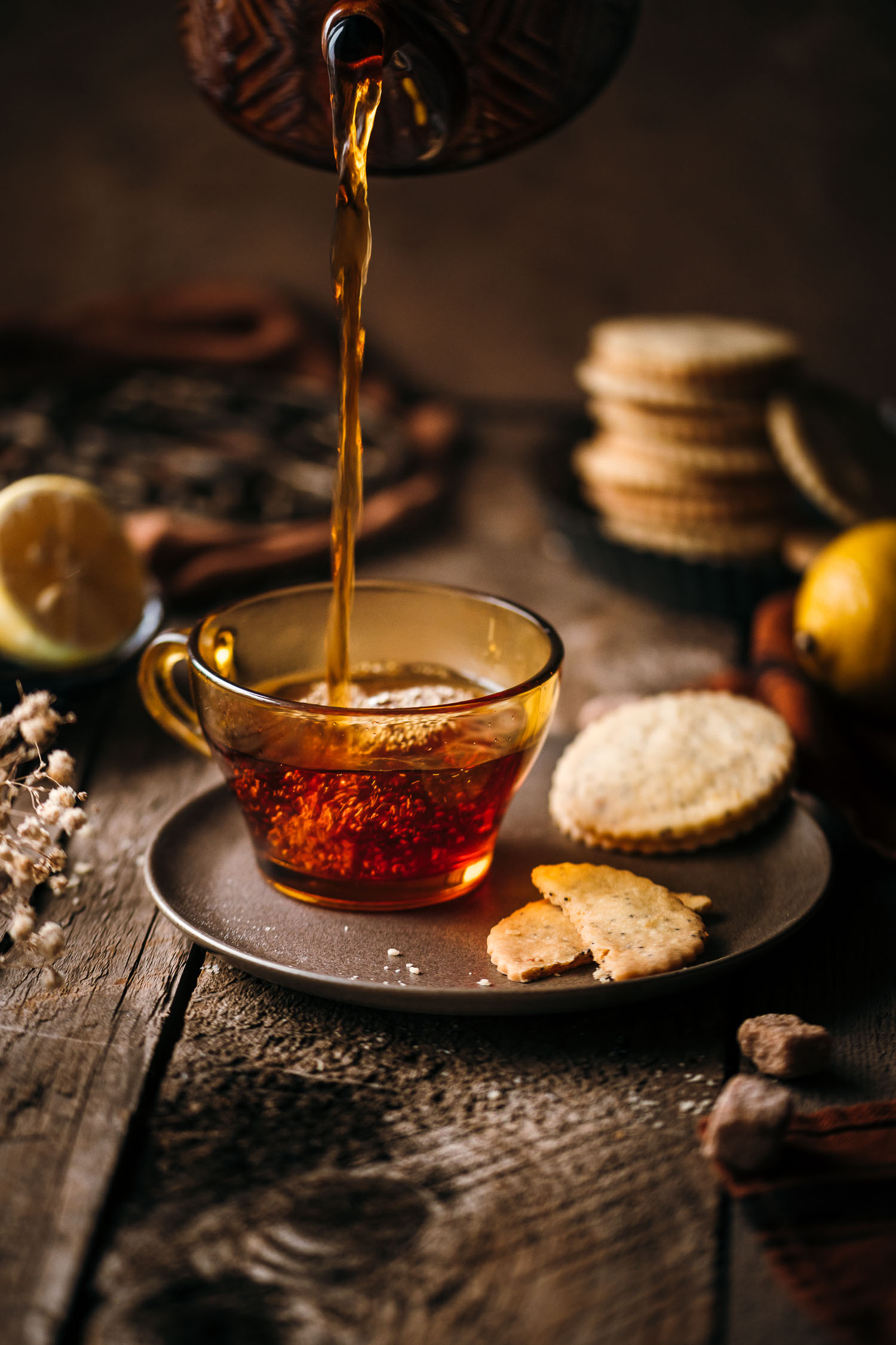 Tea poured in an amber glass mug with shortbread cookies in the background