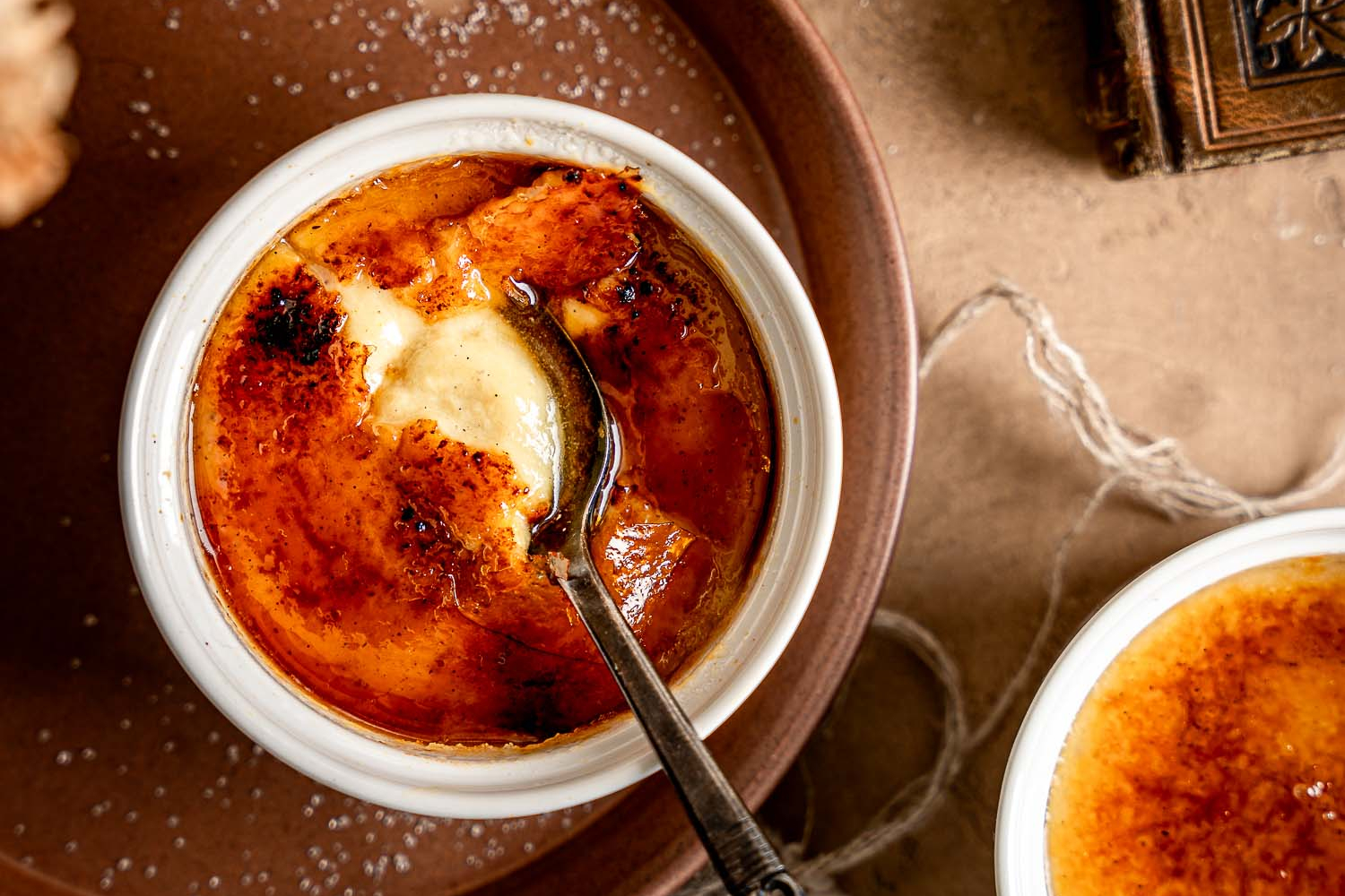 Overhead of 2 Vegan Vanilla-Cardamom Crème Brûlée broken open