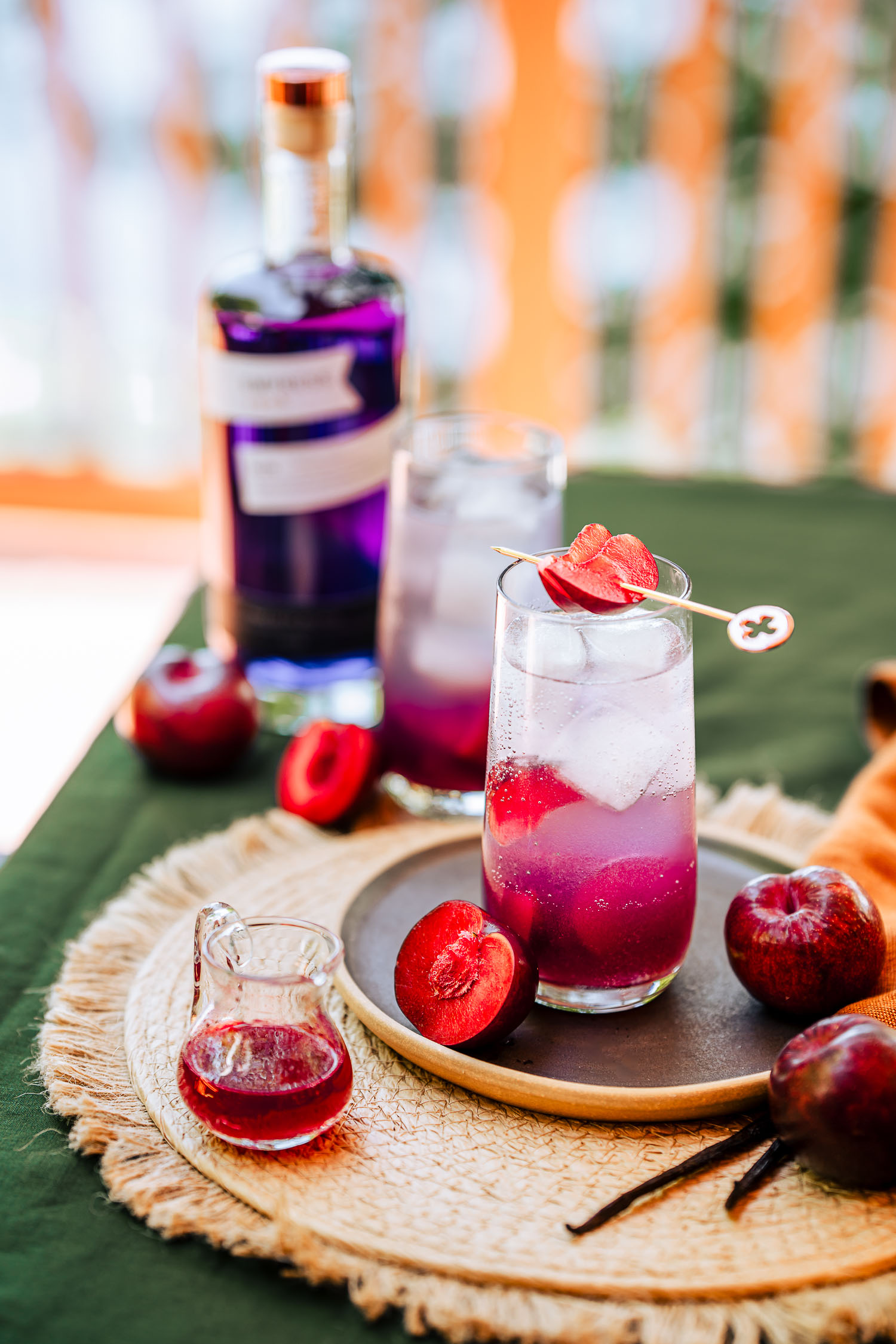Two glasses of Sweet Plum and Vanilla Gin Tonic on a table with Empress 1908 Gin