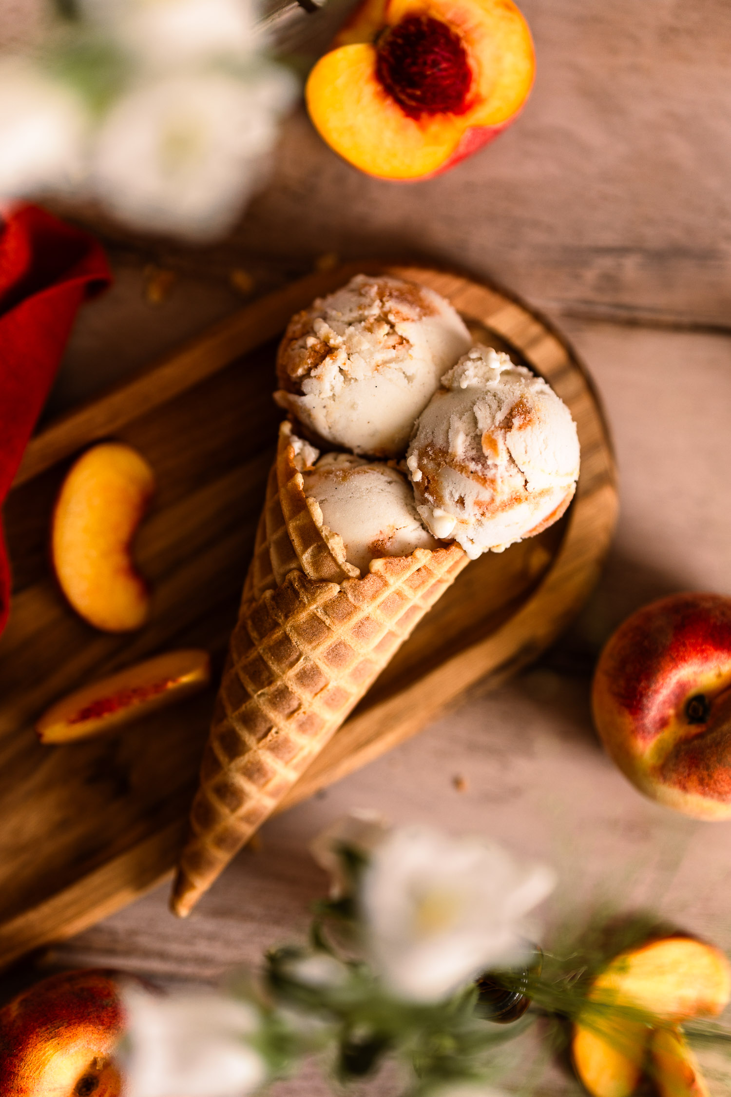 Overhead of a waffle cone filled with scoops of Vegan Peaches and Cream Ice Cream