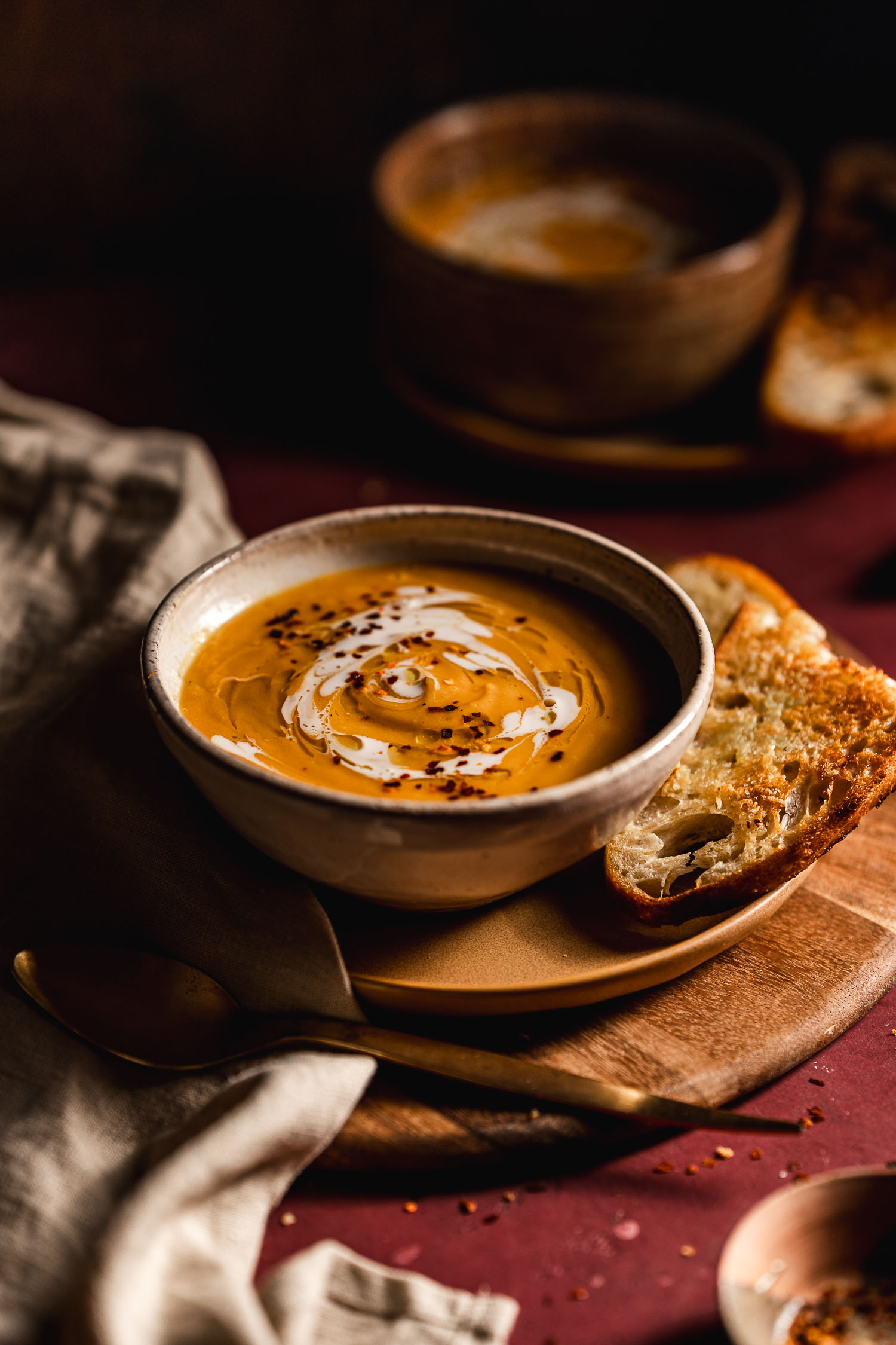 Smokey Butternut Squash Soup in a bowl with a cream and olive oil drizzle on top